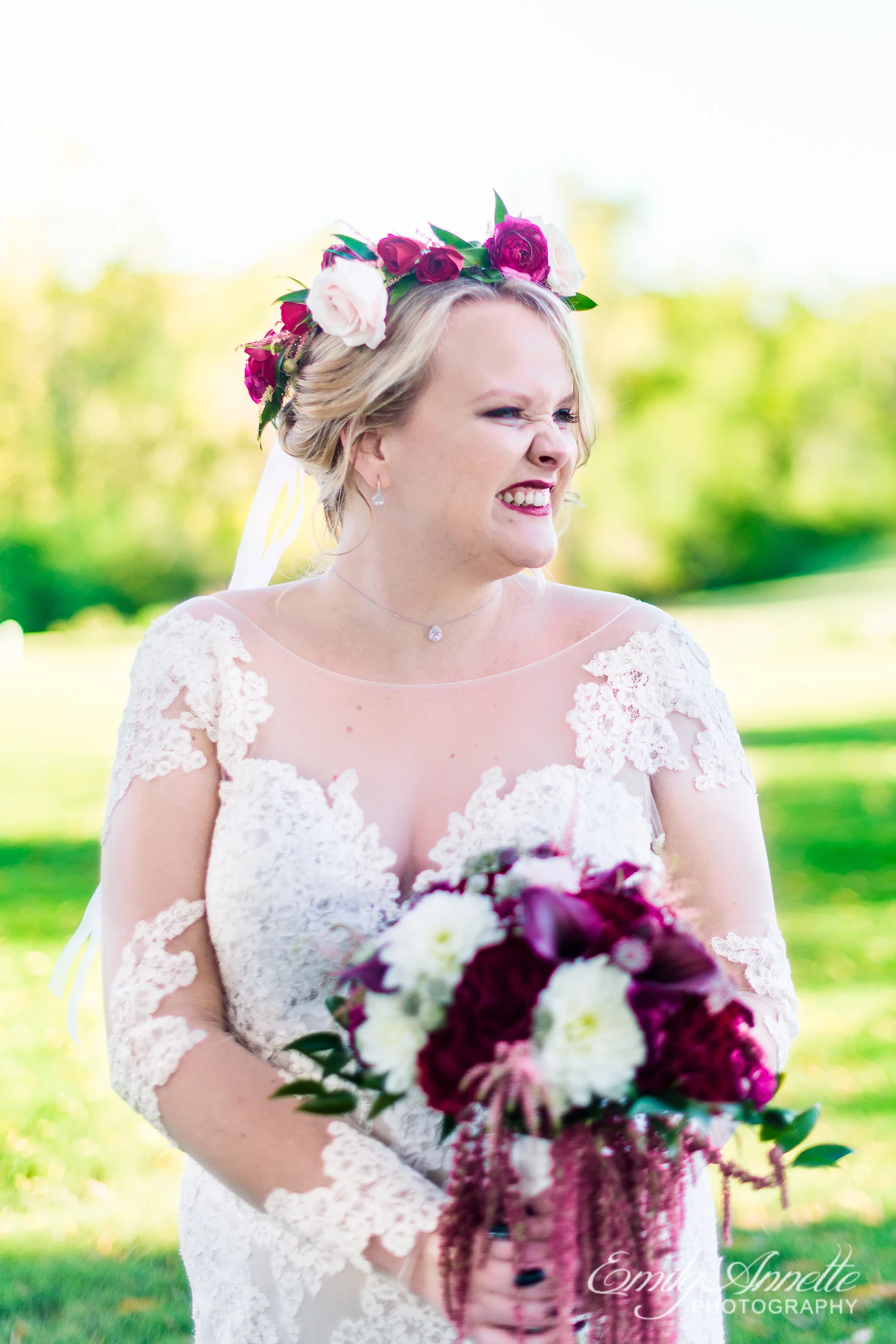 A bride wearing a lace wedding dress with sleeves and a flower crown holding her bridal bouquet on the golf course at Willow Oaks Country Club in Richmond, Virginia