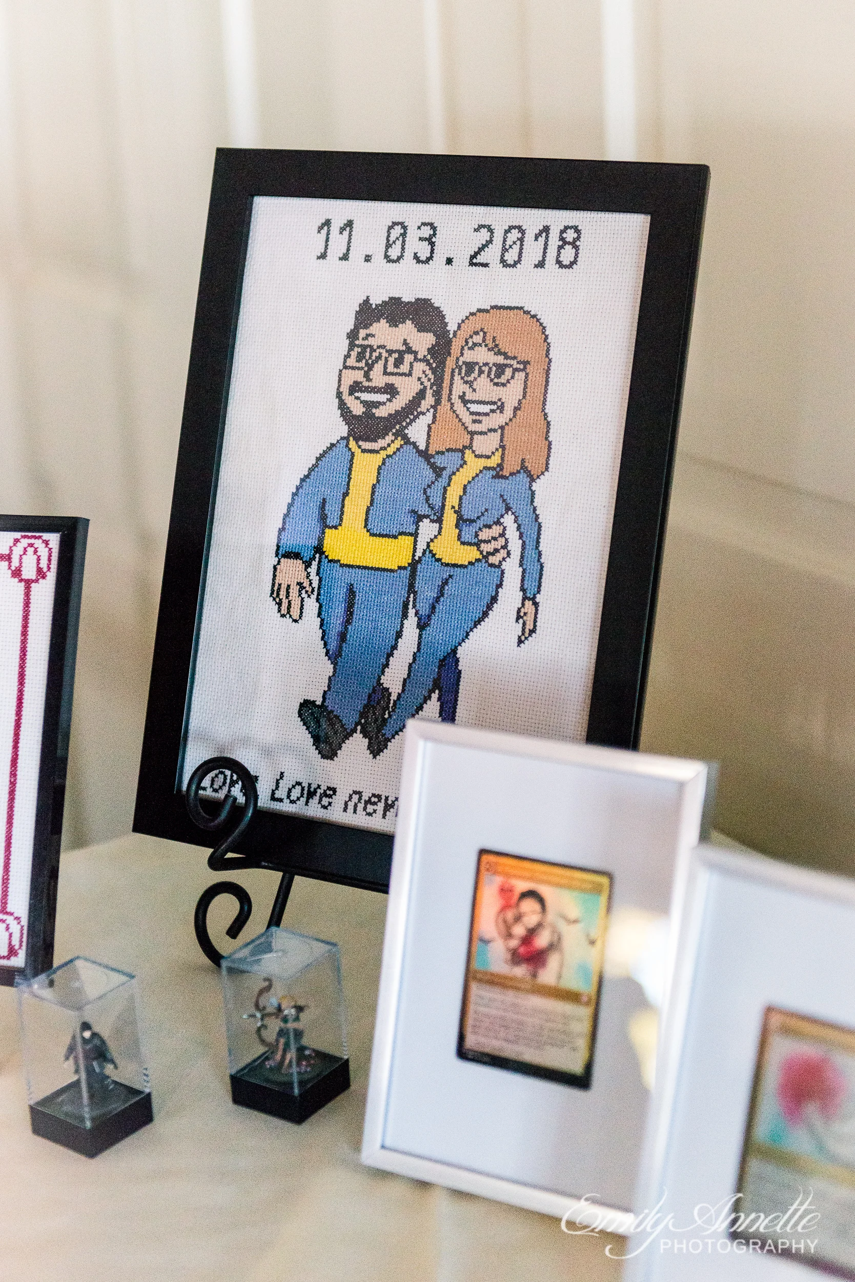 A cross stitch portrait of the bride and groom as characters from Fallout at a wedding reception at Willow Oaks Country Club in Richmond, Virginia