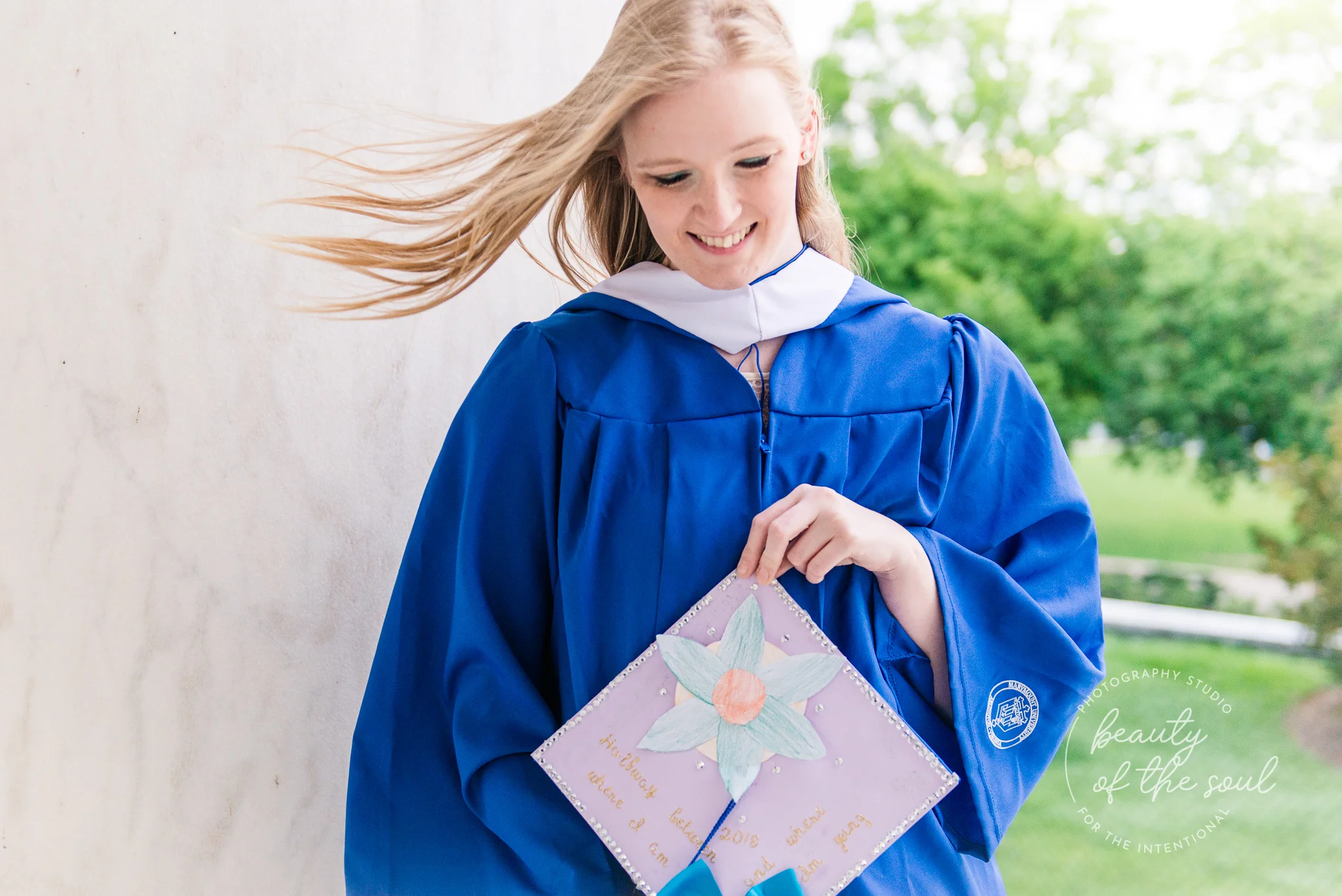 A college grad poses within the columns of the Jefferson Memorial for a Tidal Basin cap and gown session in Washington, DC before her graduation from Marymount University in Arlington, Northern Virginia