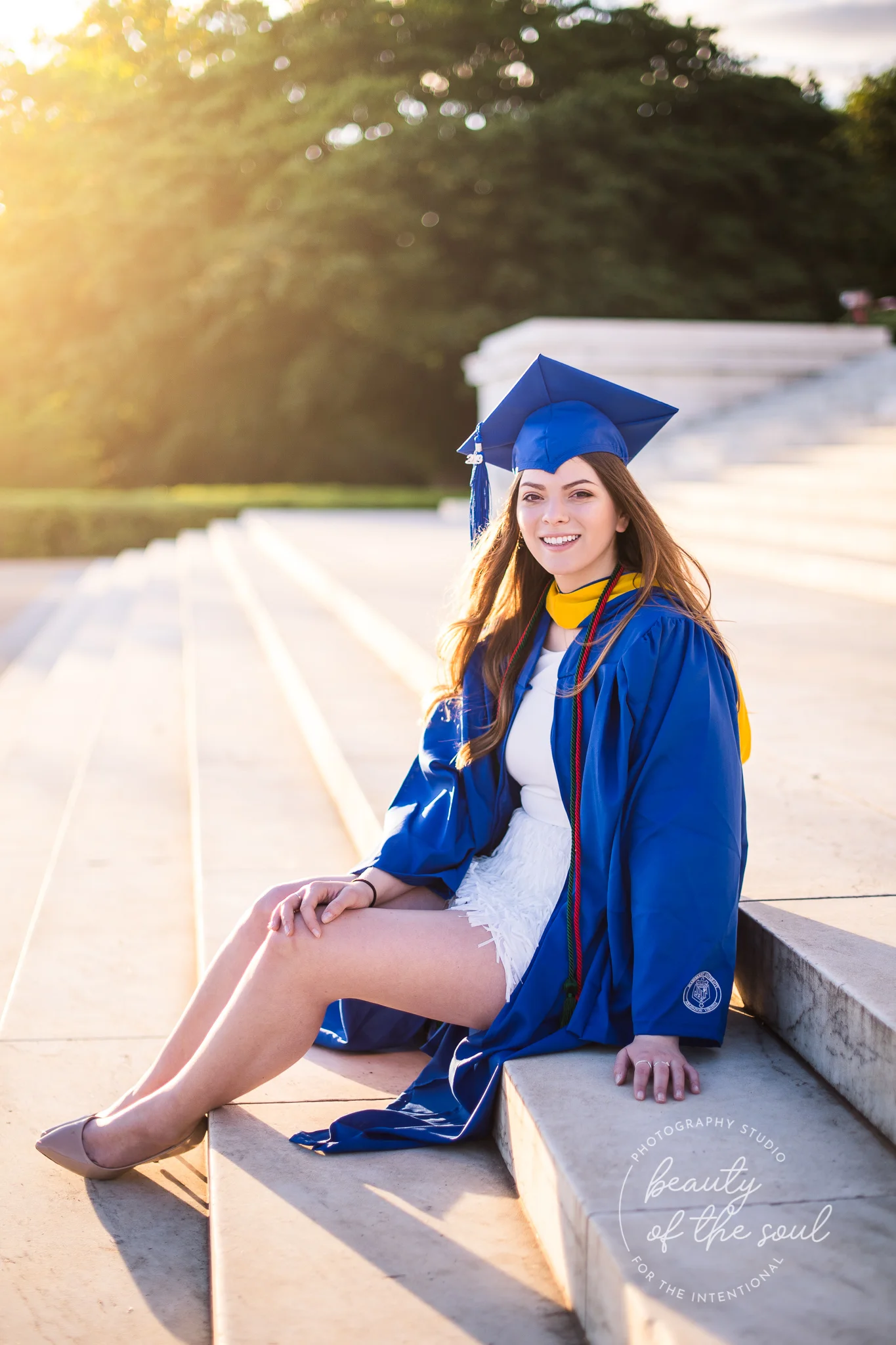 A graduate from Marymount University in Arlington, Northern Virginia sitting on the steps of the Jefferson Memorial for her cap and gown session in Washington, DC