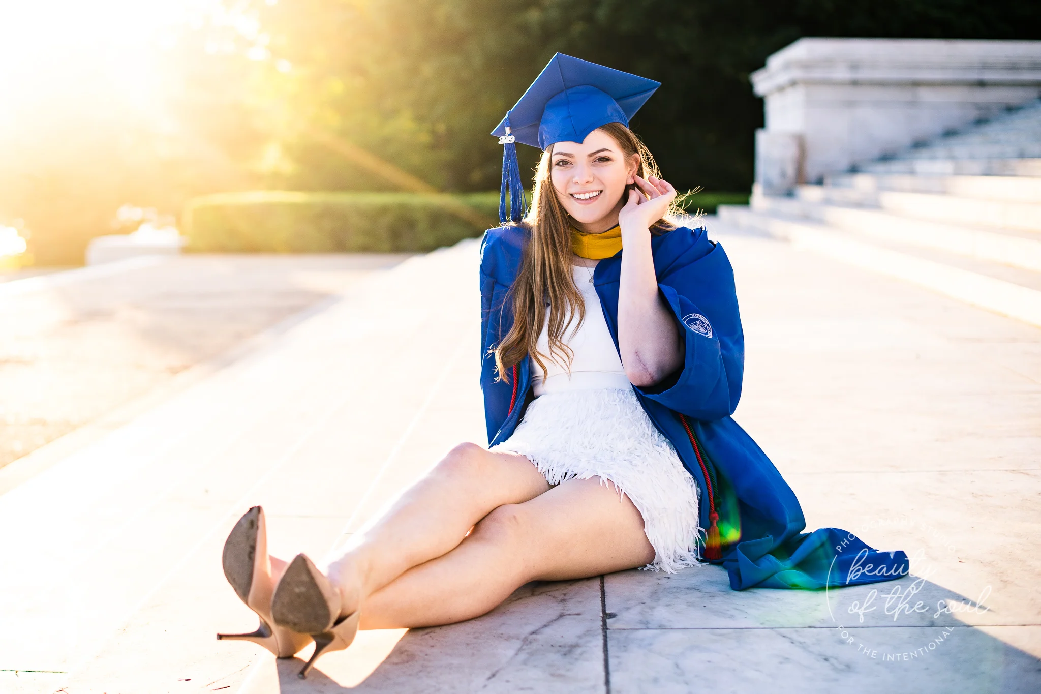 A graduate from Marymount University in Arlington, Northern Virginia sitting on the steps of the Jefferson Memorial for her cap and gown session in Washington, DC