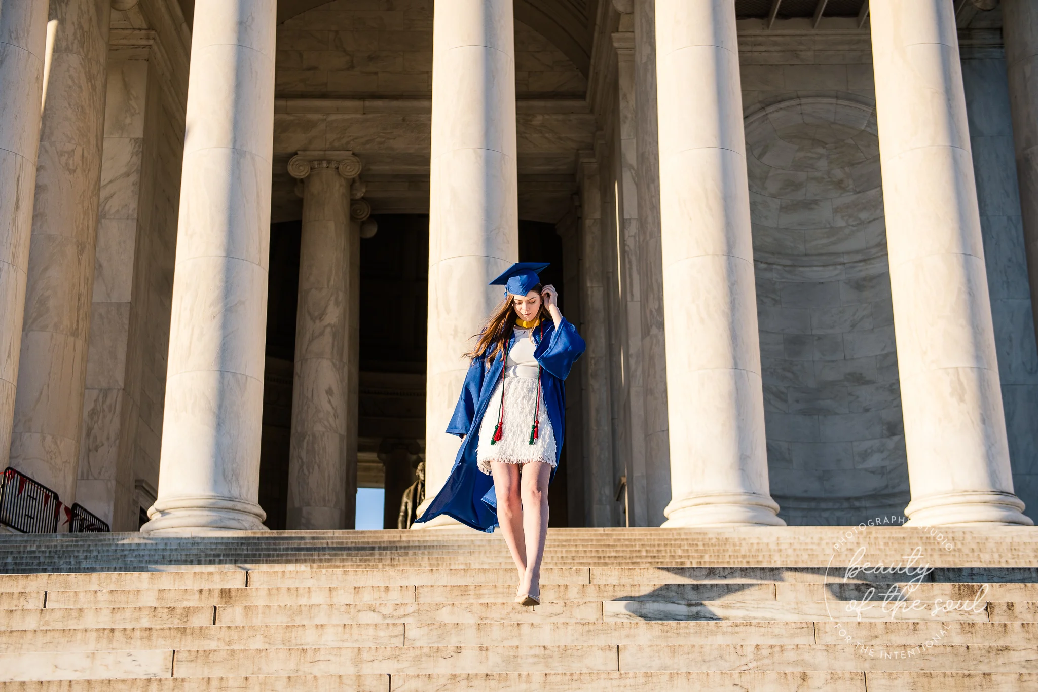 A graduate from Marymount University in Arlington, Northern Virginia walking down the steps of the Jefferson Memorial for her cap and gown session in Washington, DC