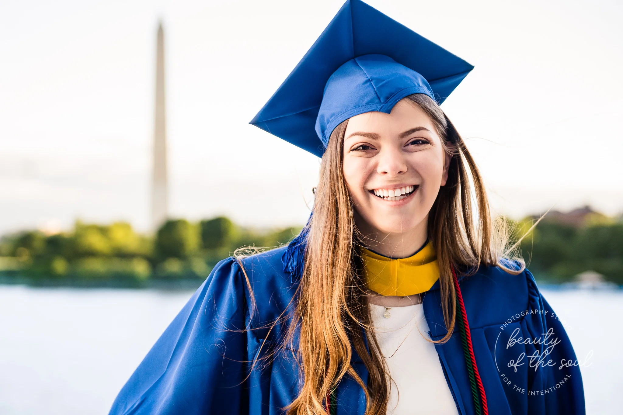 A graduate from Marymount University in Arlington, Northern Virginia standing in front of the Washington Monument and the Tidal Basin for her cap and gown session in Washington, DC