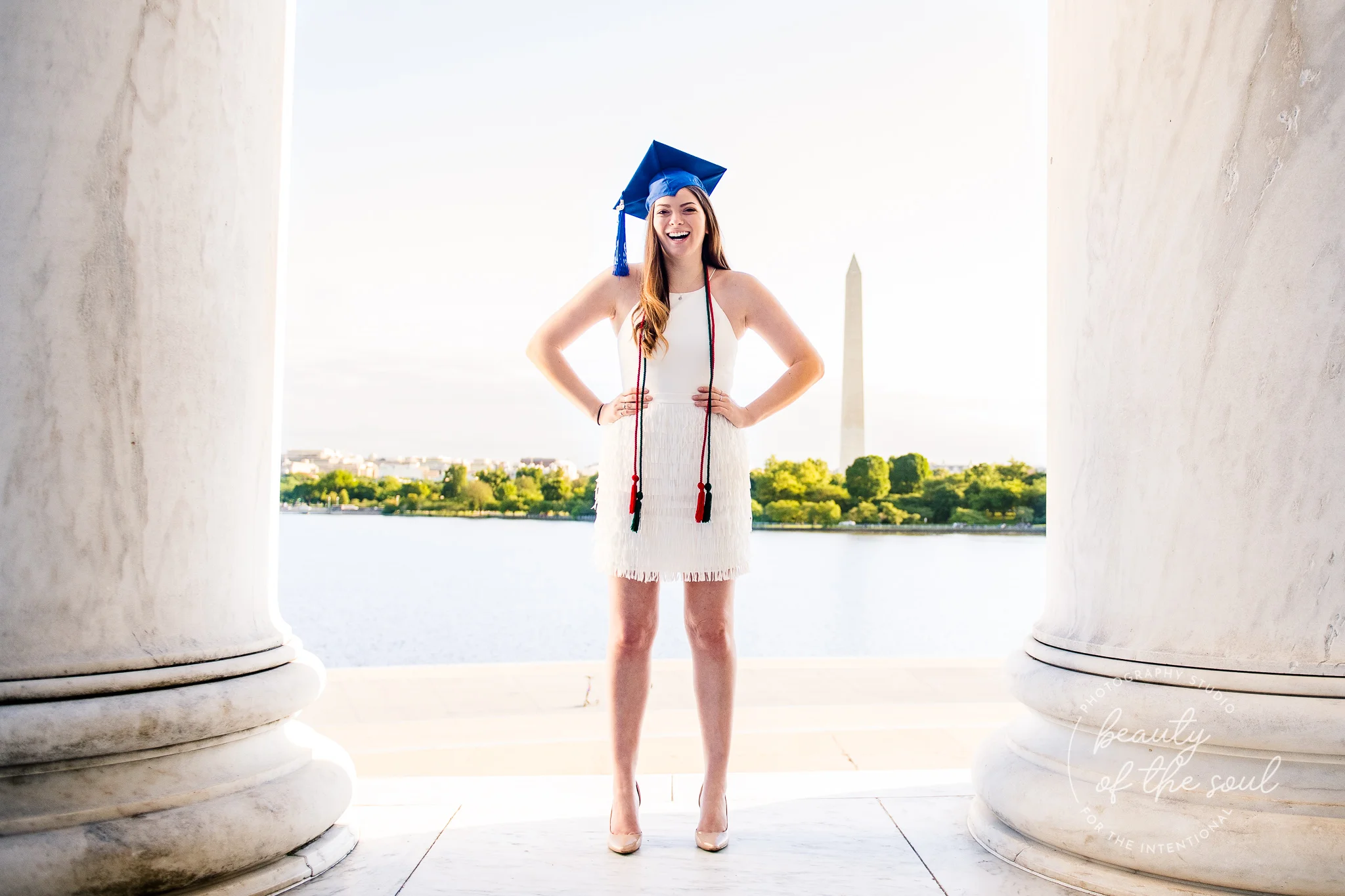 A graduate from Marymount University in Arlington, Northern Virginia standing in front of the Washington Monument at the Jefferson Memorial for her cap and gown session in Washington, DC