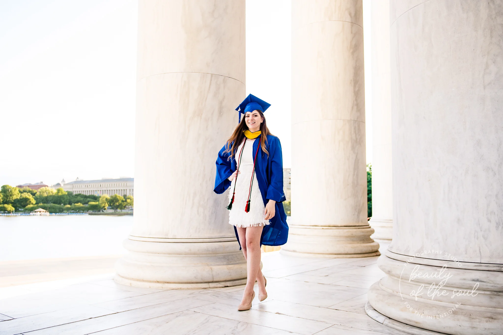 A graduate from Marymount University in Arlington, Northern Virginia walking in the Jefferson Memorial for her cap and gown session in Washington, DC