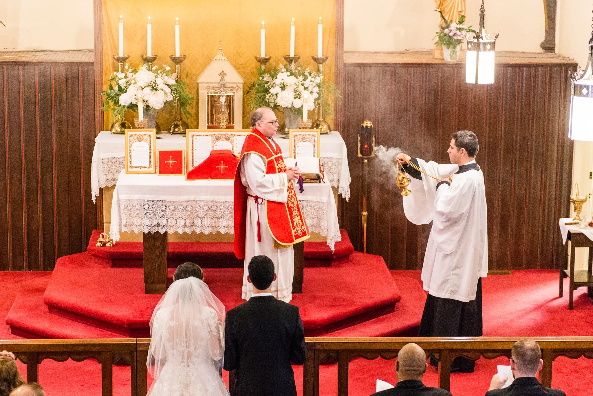 An altar server spreads incense before a priest for a Traditional Latin Mass during a Catholic wedding ceremony at the Chapel of Immaculate Conception in Leesburg, Northern Virginia