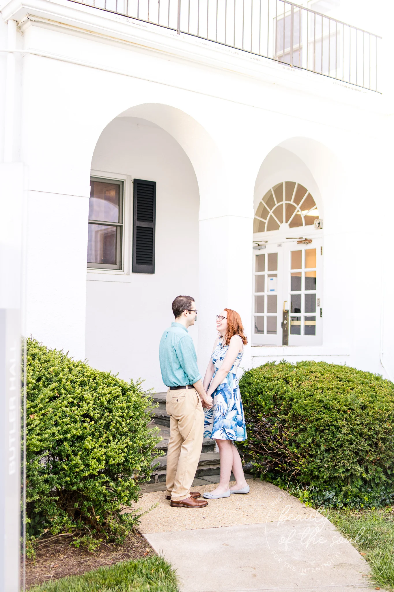 An engaged couple hold hands during their summer engagement session at Marymount University in Arlington, Northern Virginia