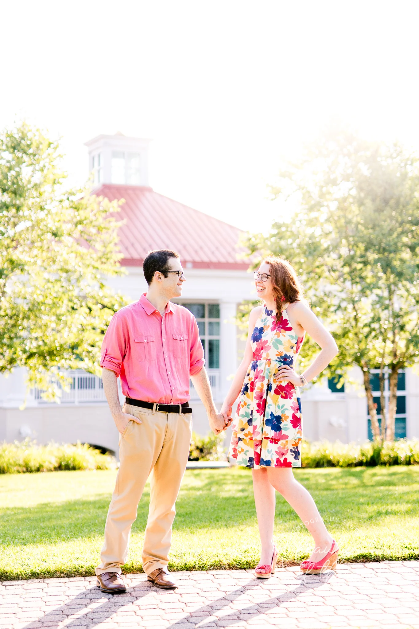 An engaged couple stand and pose together on Ireton Lawn at Marymount University during their summer sunrise engagement session in Arlington, Northern Virginia