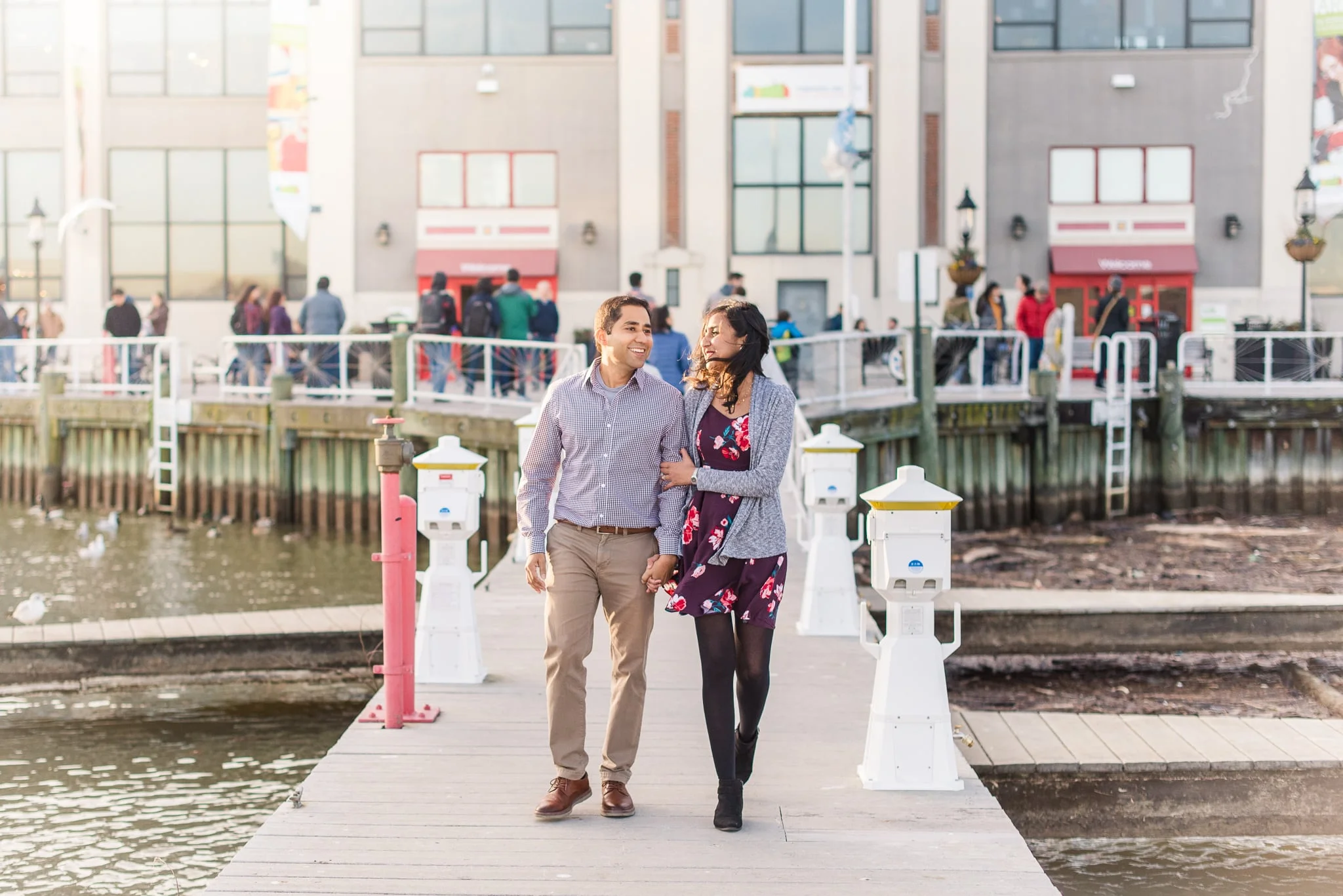 An engaged couple walks together along the pier at Old Town Alexandria in Northern Virginia