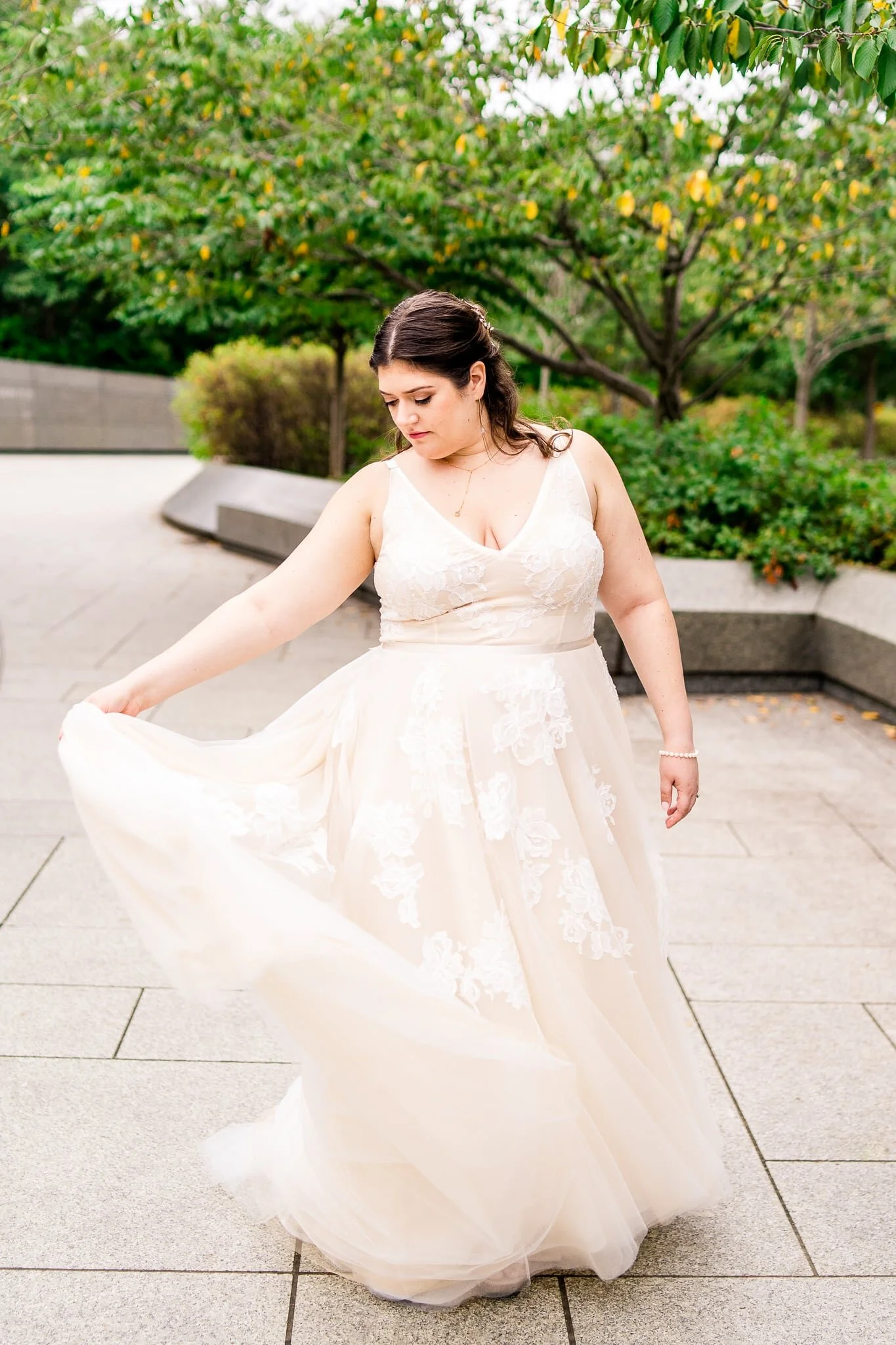 A bride twirls in her tulle wedding dress on her wedding day at the Tidal Basin near the MLK Memorial in Washington, DC