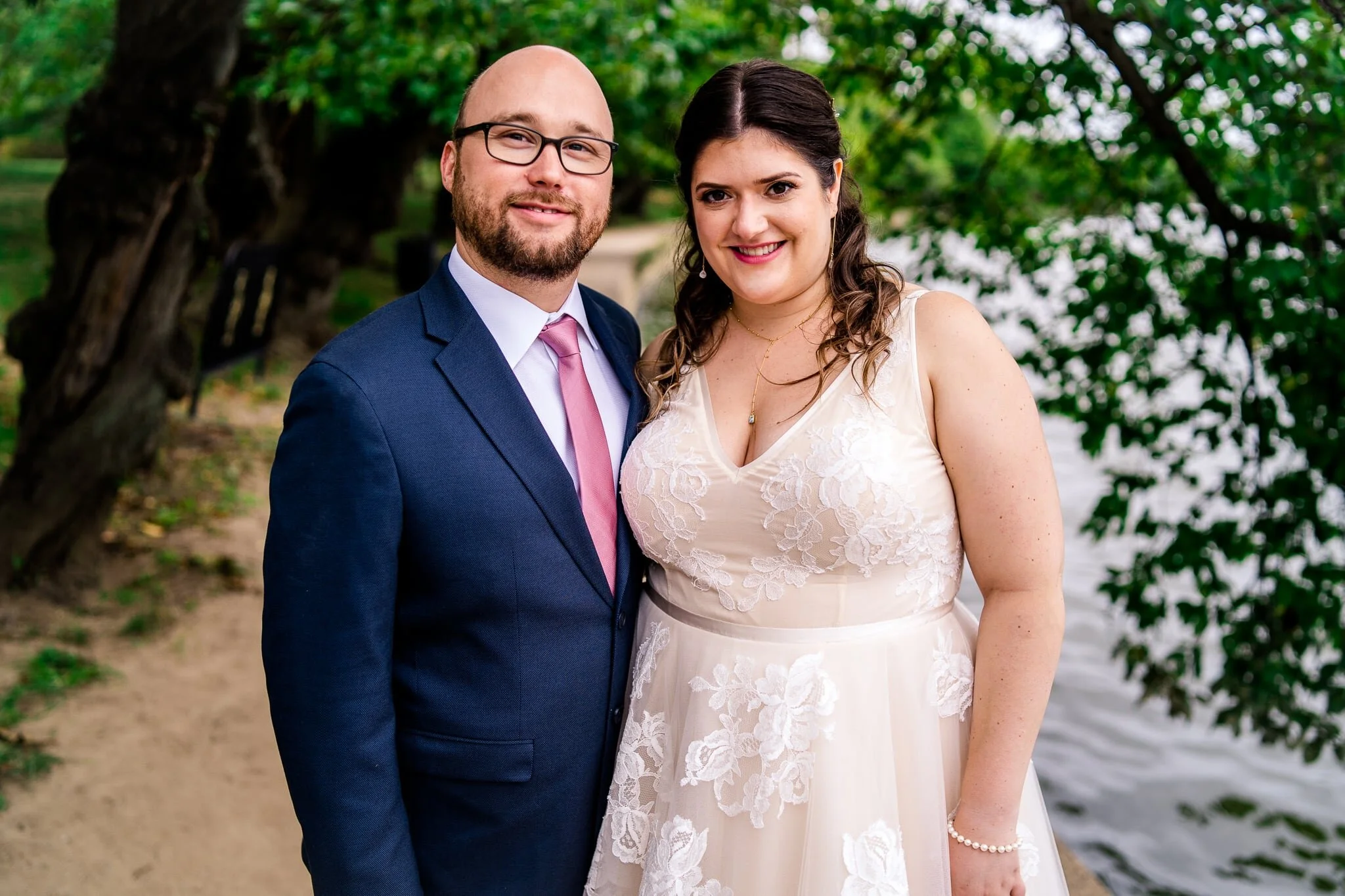 A bride and groom stand together for a classic portrait along the Potomac River on their wedding day at the Tidal Basin in Washington, DC