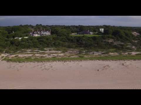 Aerial tracking shot of ocean-side estates in Easthampton, Long Island