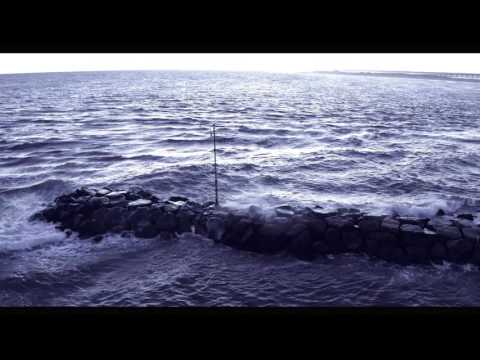 Waves crashing against jetty at and rolling ashore at Shinnecock Inlet, Long Island, NY