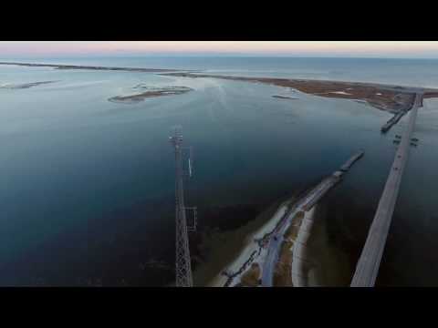 Aerial rotation around tall radio tower with views of ocean and bay, Long Island, NY