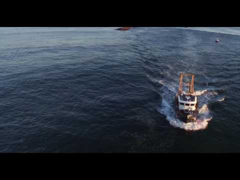 Low flyover of Coast Guard buoy tender headed out to sea at sunrise