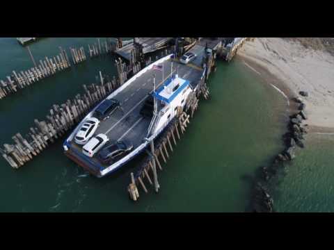 Descending aerial shot of cars disemebarking from Shelter Island, New York ferry
