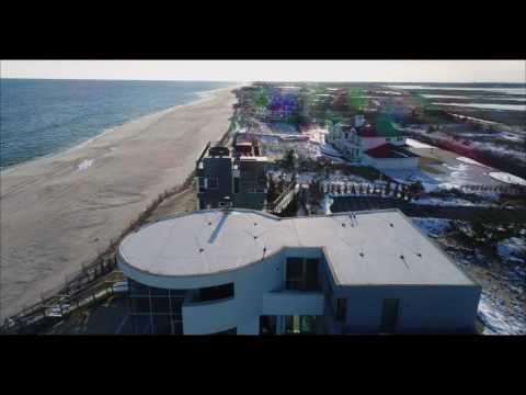 Low aerial pass over Hamptons' beachfront estates with snow on the ground