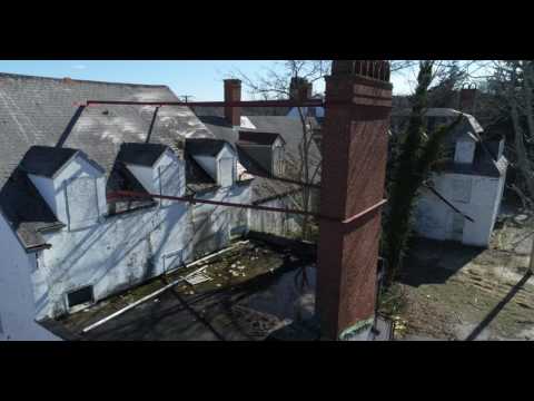 Aerial pan and tracking shot of old dilapidated hotel in the Hamptons