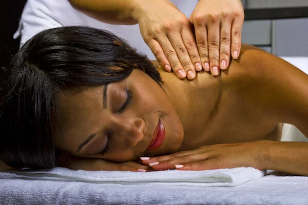  young African American female getting a massage in a spa 