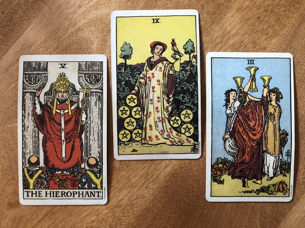 three card tarot reading with the hierophant, nine of pentacles, and three of cups