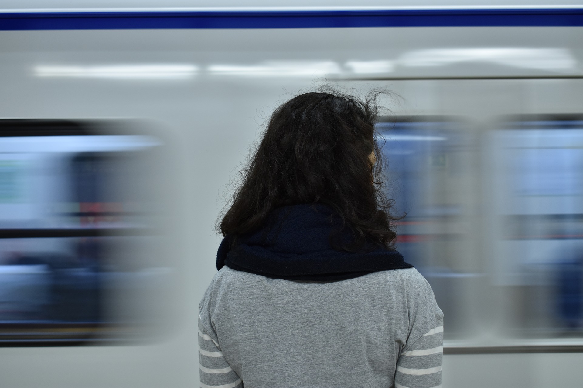 Девочка в поезде в движении. Девушка спиной метро размытый фон. Картинка девушка перед путями метро движения. В метро очень сильно кружится голова. Пребывающий поезд