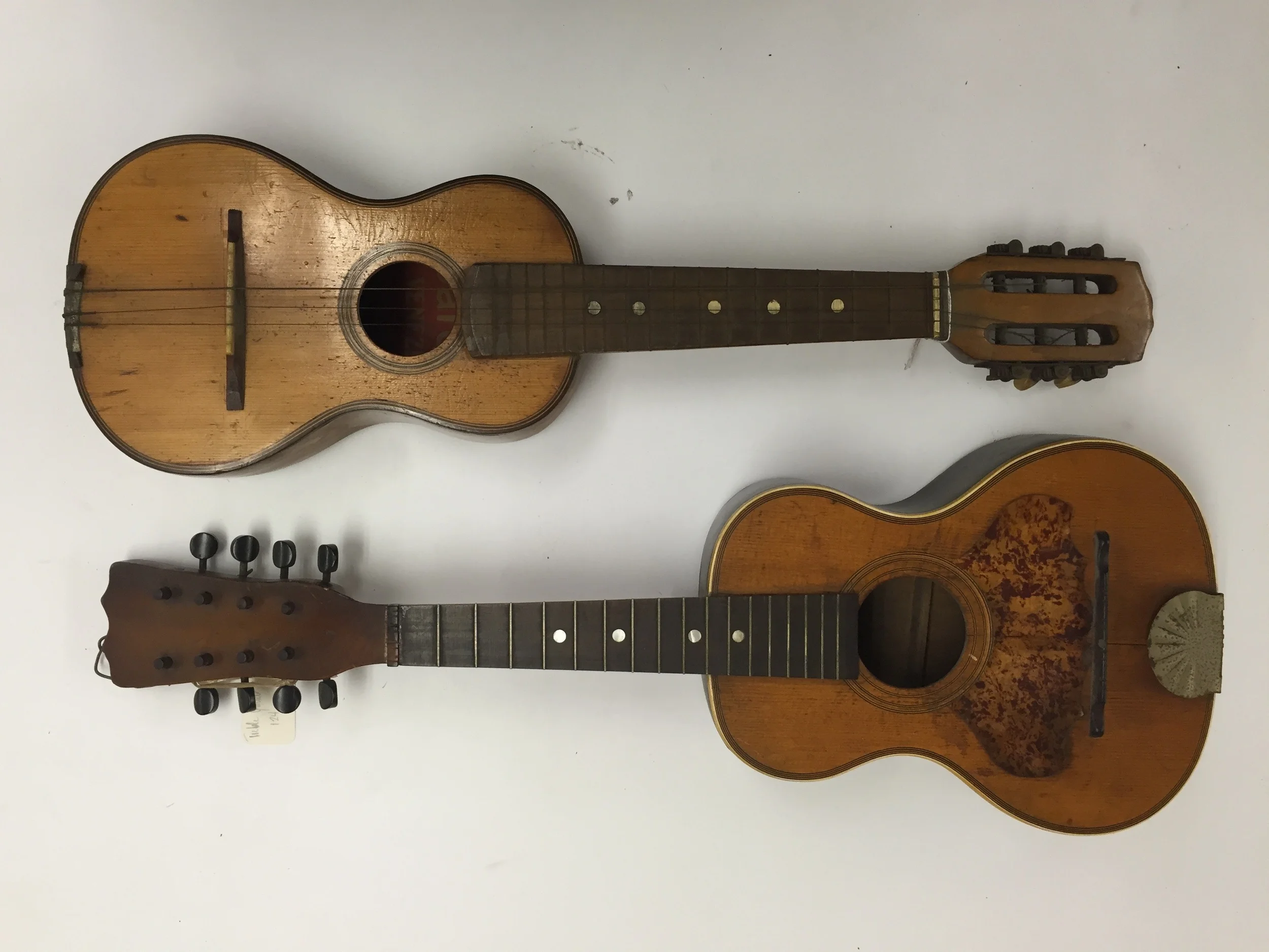 A child-sized guitar and a guitar-shaped mandolin, ca. 1920