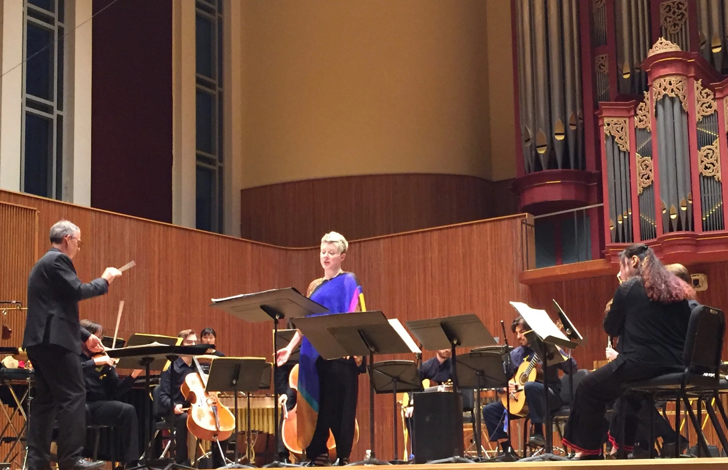 Tim Weiss conducts, Tony Arnold sings; guitarist Mohit Dubey partially visible.