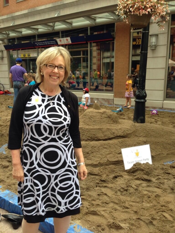 MP Elizabeth May infront of the Team Green Party Sandcastle