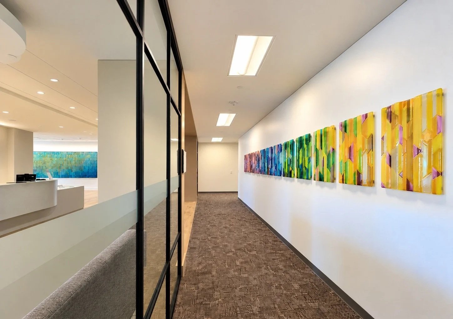Custom fused glass art installation commissioned by Silver Chase Design for Houston Methodist HEAL Cancer Wellness, featuring colorful architectural glass panels.