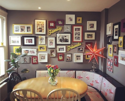 Matthew Shaw 's gorgeous dining corner is edge to edge with collected family photographs in consistent colour frames.