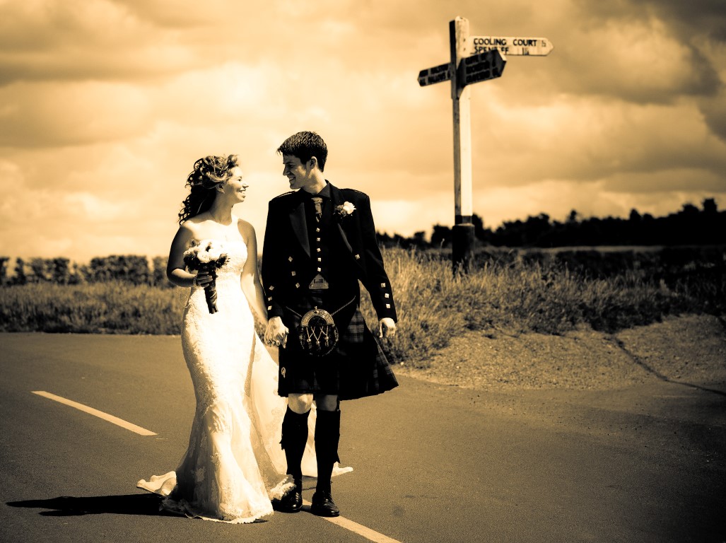 couple walking with vintage signpost in the background