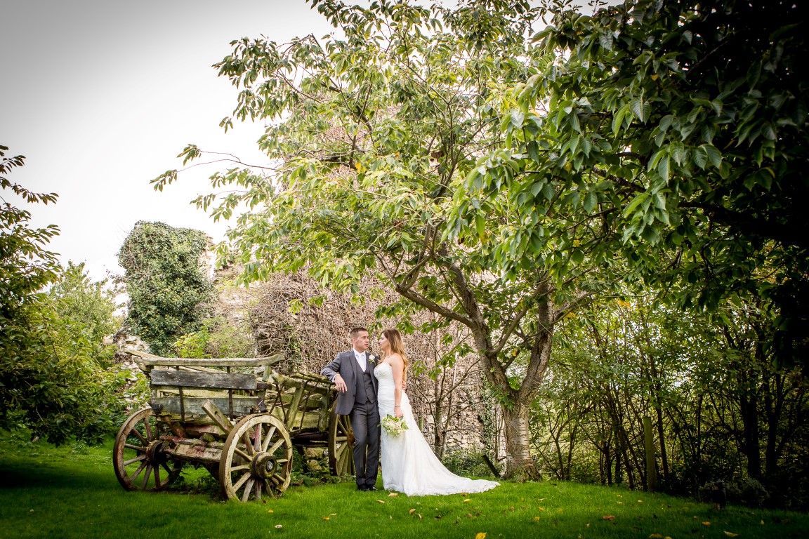 Bride and groom by vintage cart