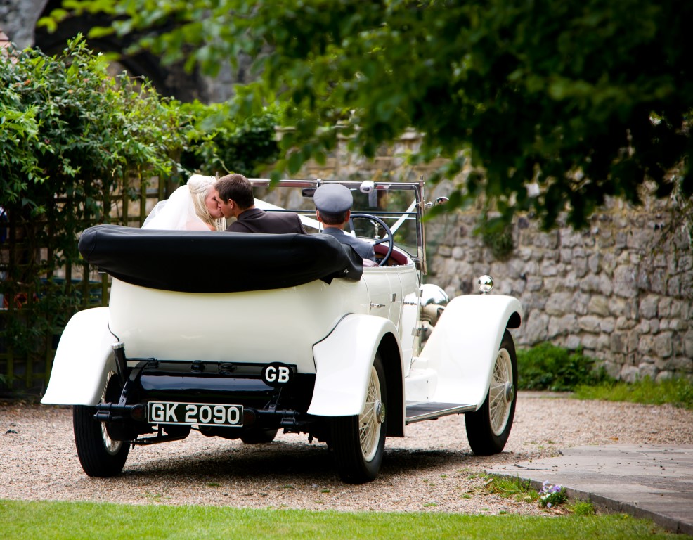 bride and groom in a car on the lawn