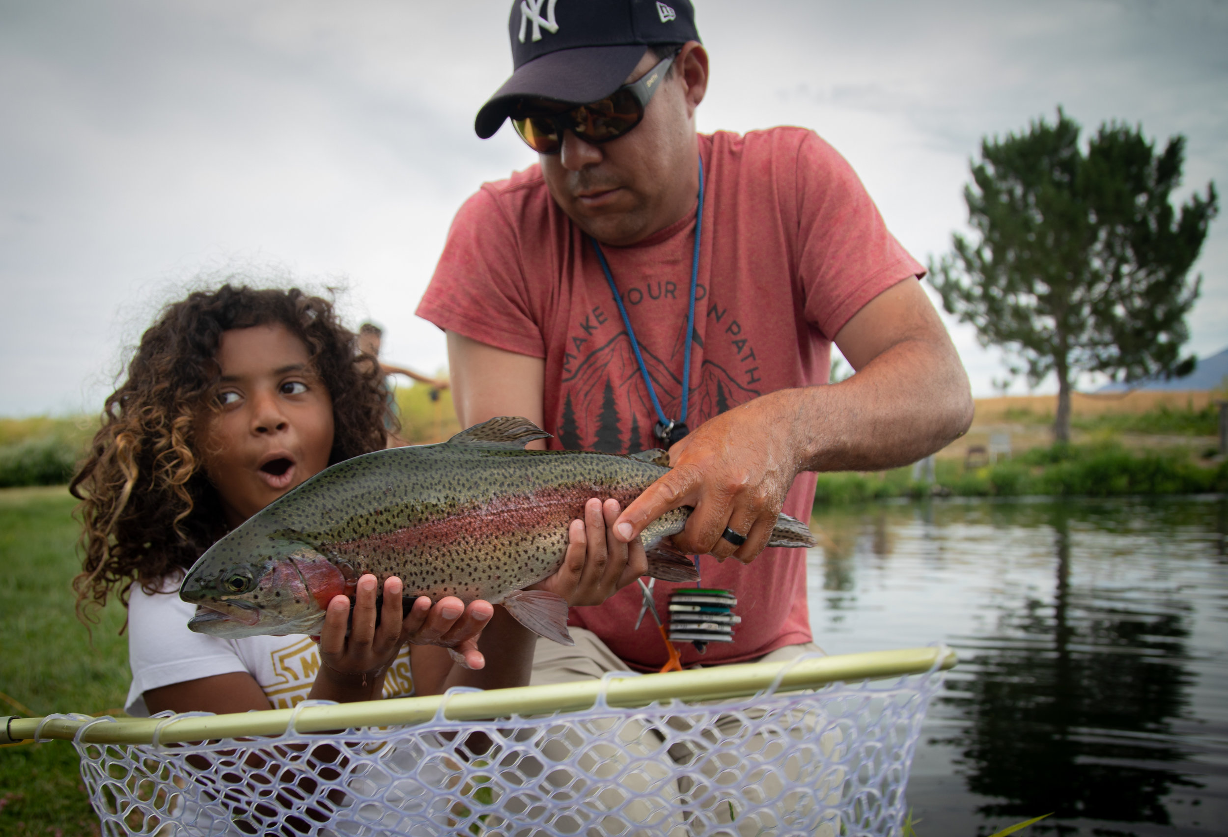  Mariah, 9, holds her catch with mentor, Kenny Garcia at a trout pond on Saturday, July 14, 2018, in Smithfield on an outing with The Mayfly Project, a national non-profit that uses fly fishing to mentor foster care children. Mariah was adopted in 20