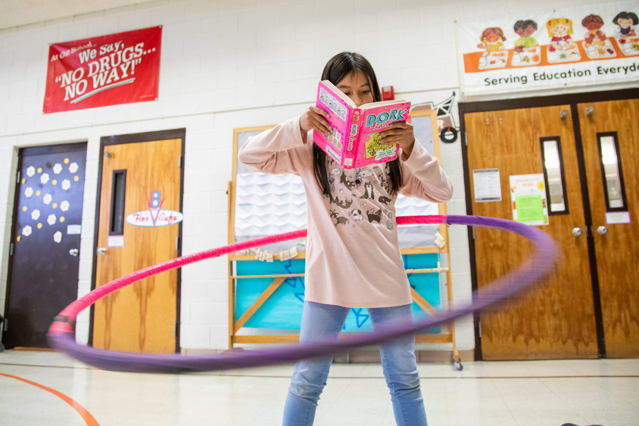 Gabriella Juarez-Lamoreaux catches up on some reading while hula hooping at the afterschool program at South Clearfield Elementary on Friday, Nov. 15, 2019. 