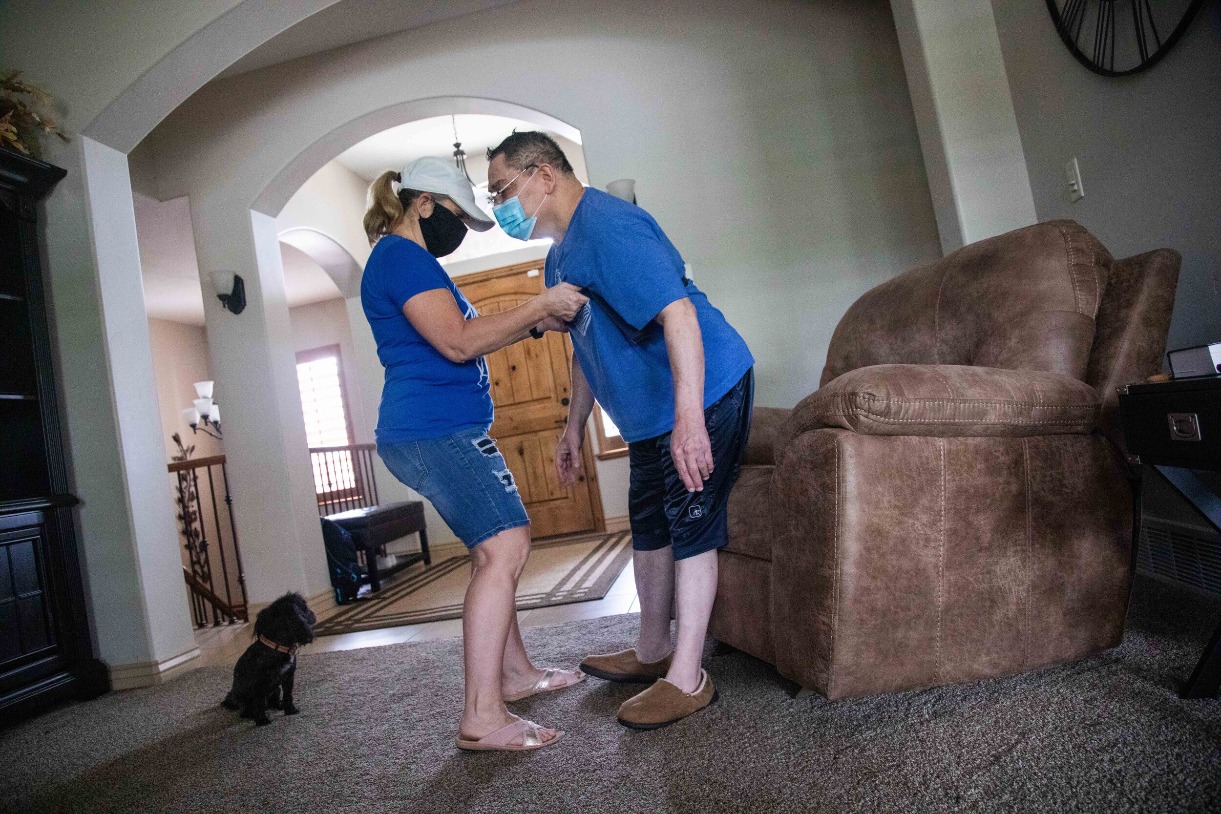  Denise Vigil-Thieldfoldt, left, helps her cousin Ron Vigil sit down in their home on Friday, May 22, 2020, in Syracuse, Utah. 
