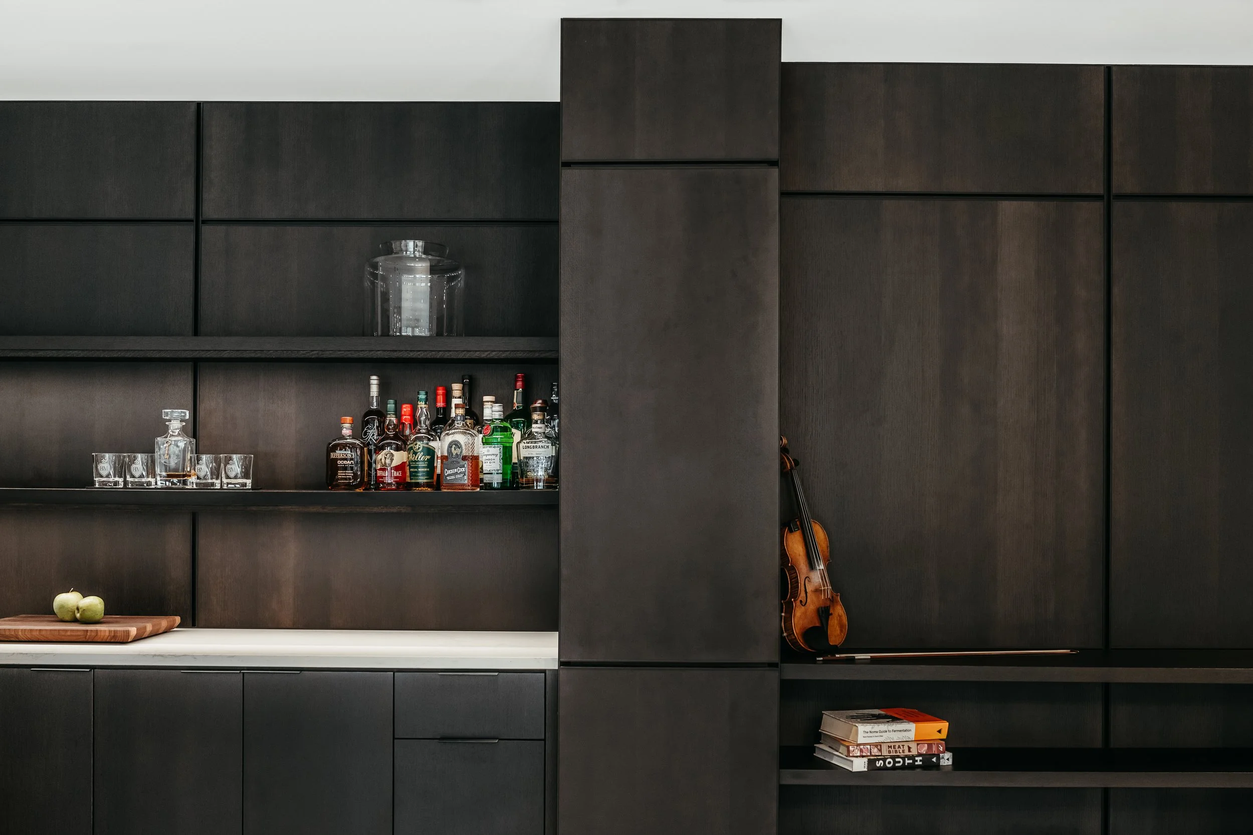 Custom woodwork by Sunnyside Millwork Black rift white oak panel wall with India ink finish and Fry Reglet aluminum reveals creating clean architectural wall transitions in modern kitchen remodel in Kernersville, North Carolina