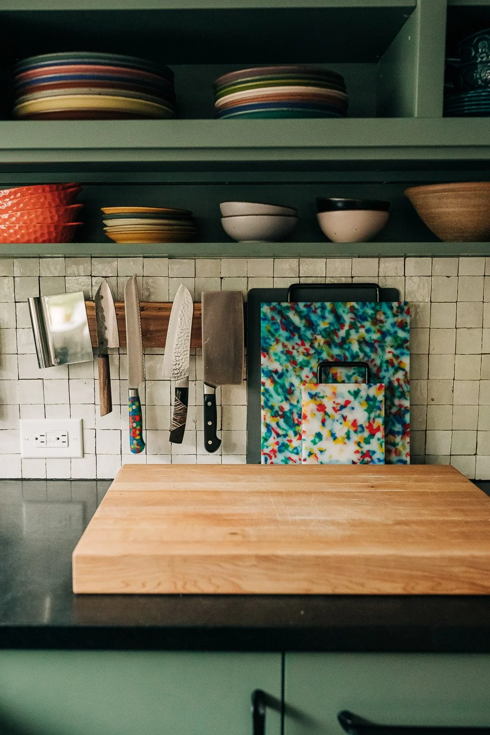 Custom knife storage rail and butcher block prep station integrated into painted cabinetry and millwork system in Bat Cave NC