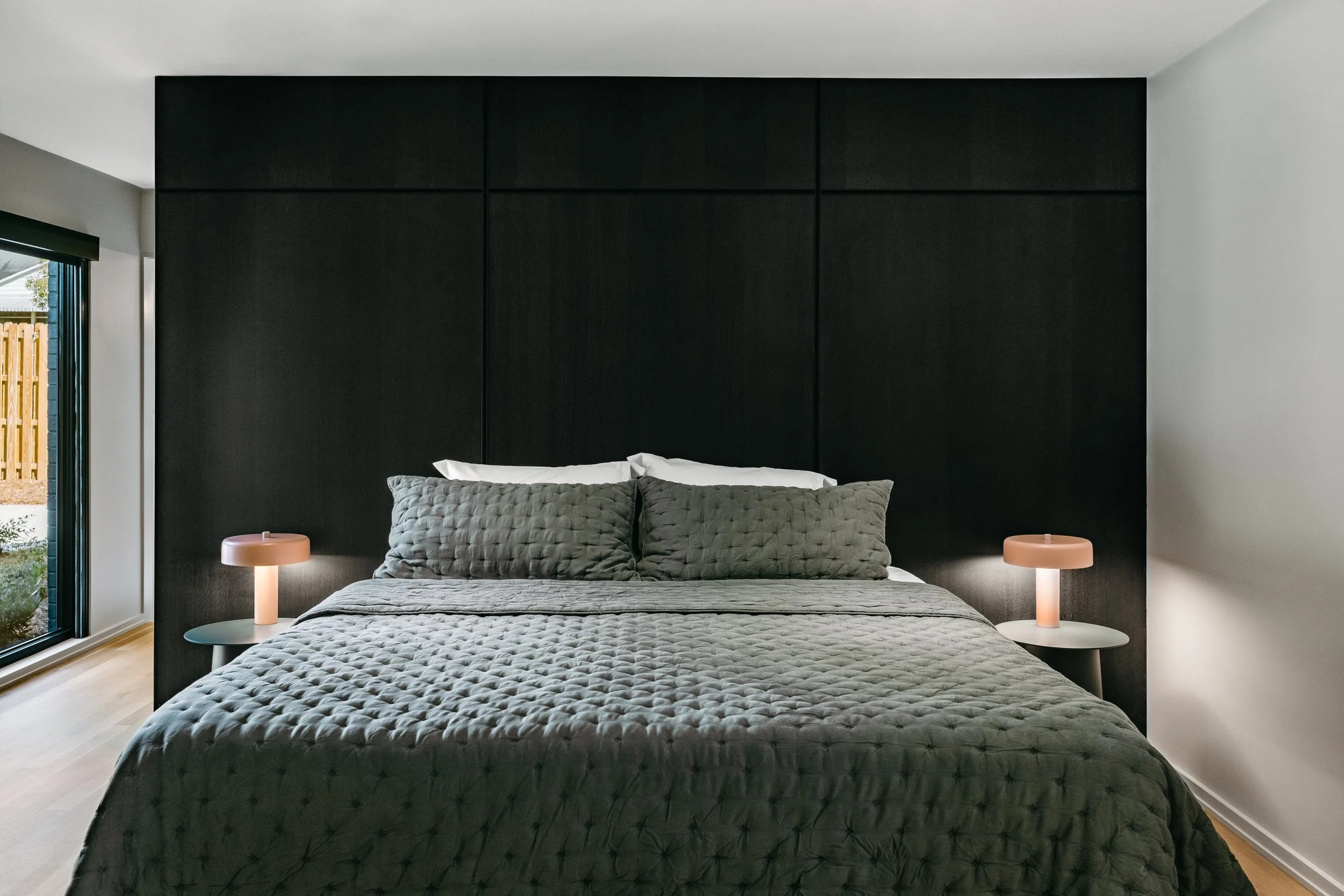 Custom woodwork by Sunnyside Millwork Black rift white oak panel wall with India ink finish and Fry Reglet aluminum reveals creating clean architectural wall transitions in Kernersville, North Carolina integrated flush seams behind bed, custom archit