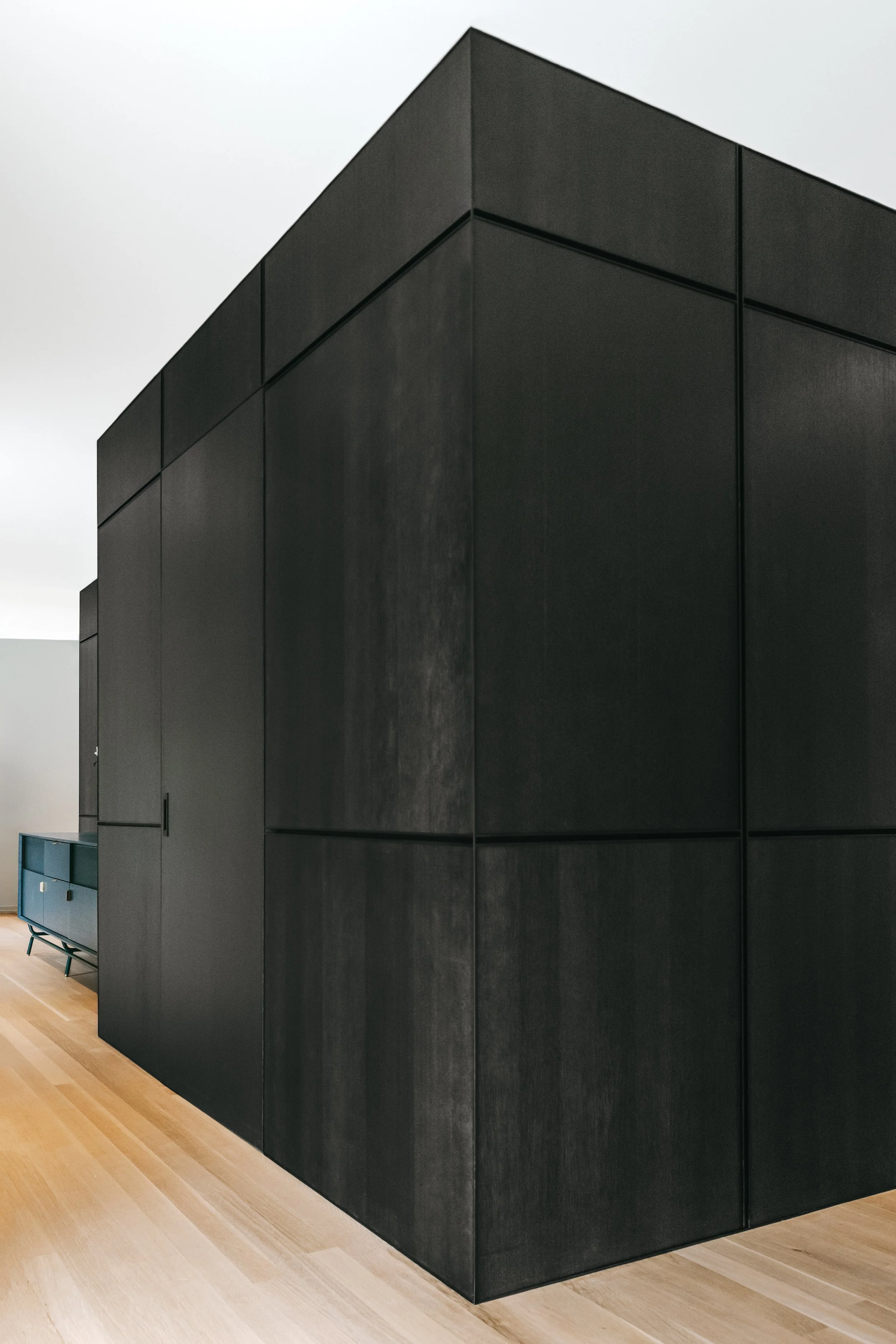 Custom woodwork by Sunnyside Millwork Black rift white oak panel wall with India ink finish and Fry Reglet aluminum reveals creating clean architectural wall transitions in Kernersville, North Carolina integrated flush seams, custom architectural mil