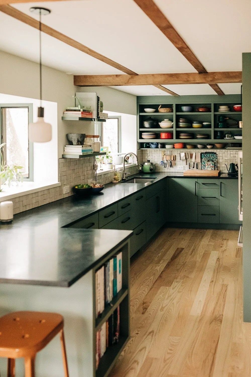 Wide angle Custom kitchen millwork in mountain home in Bat Cave North Carolina near Lake Lure and Chimney Rock, featuring painted cabinetry, open shelving, and East Fork Pottery from Asheville NC