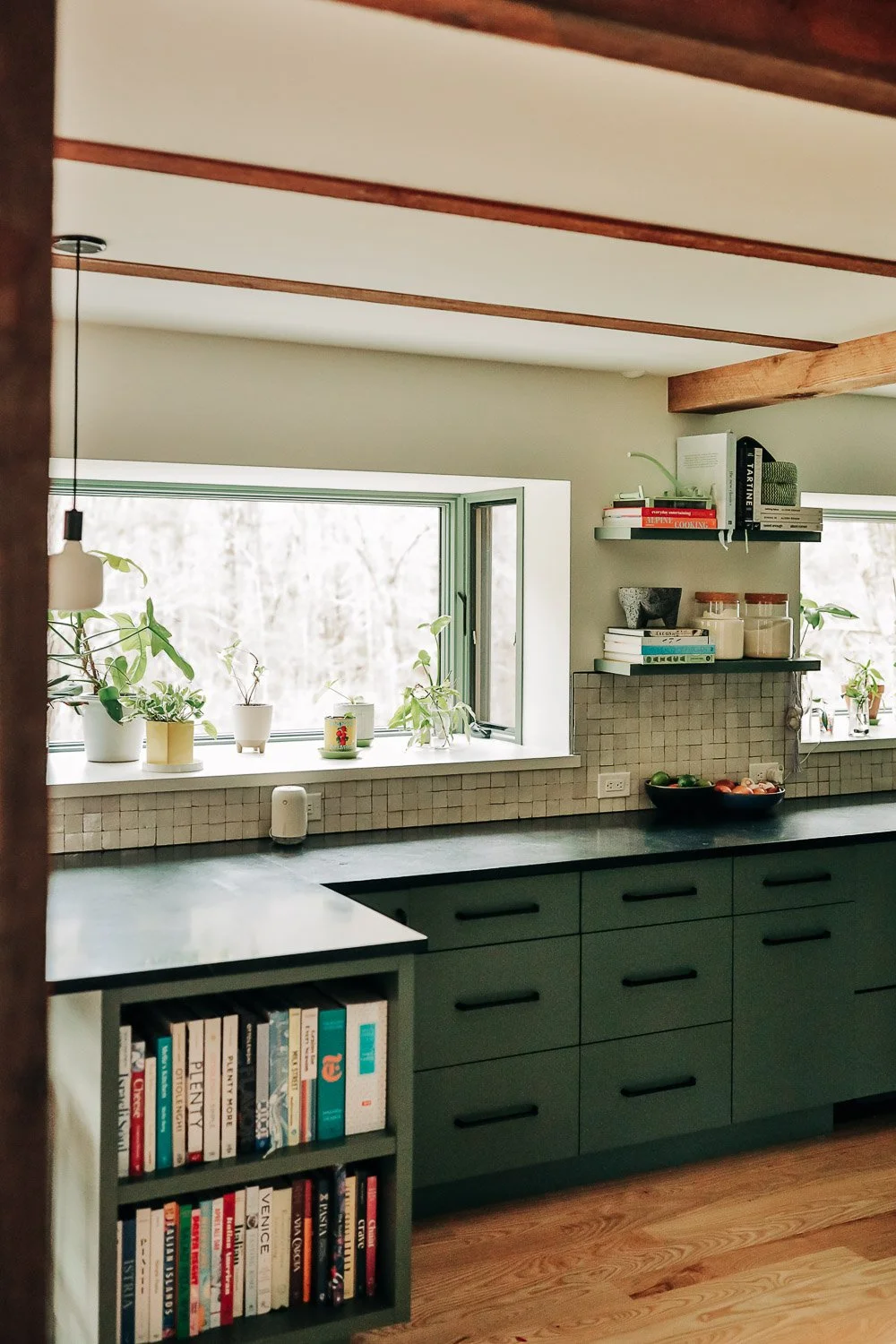 Built-in bookshelf integrated into painted kitchen island with custom millwork storage in Bat Cave North Carolina