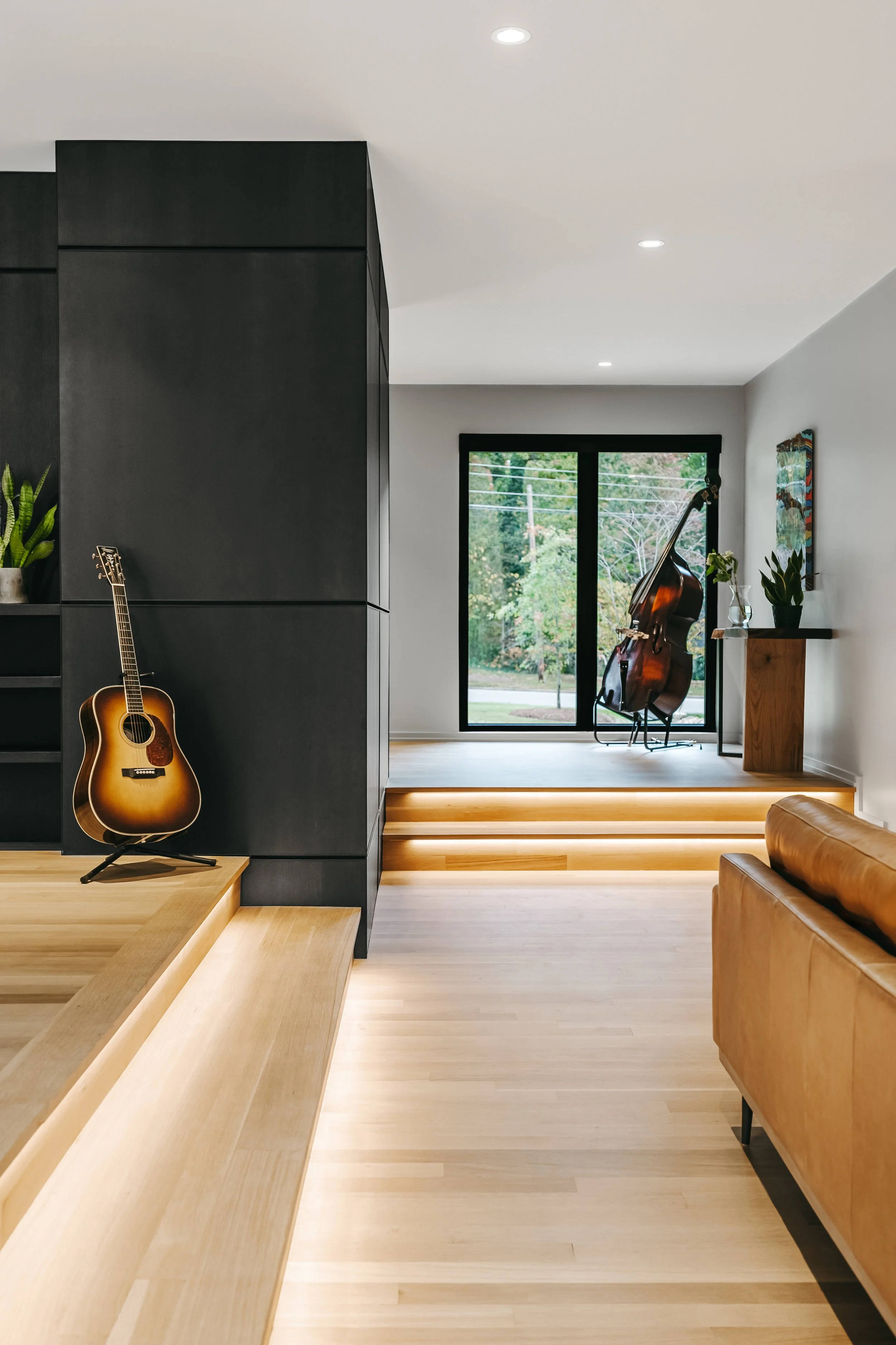 Custom woodwork by Sunnyside Millwork Black rift white oak panel wall with India ink finish and Fry Reglet aluminum reveals creating clean architectural wall transitions in modern kitchen remodel in Kernersville, North Carolina
