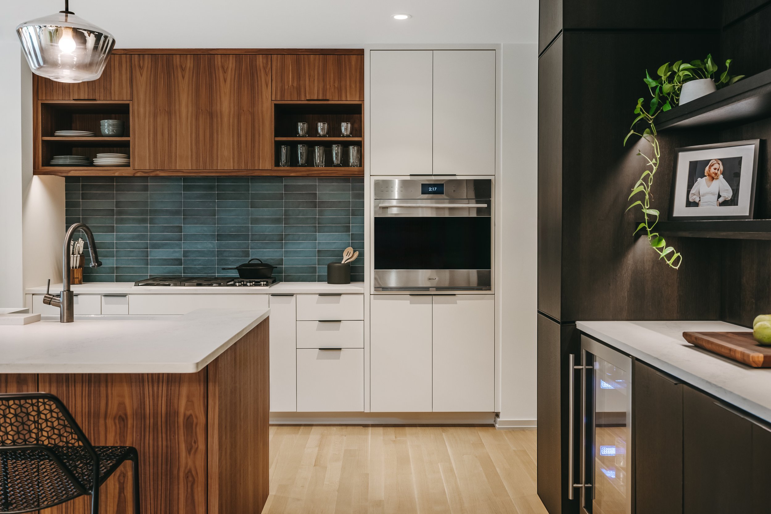 Custom woodwork by Sunnyside Millwork Open concept Two-tone kitchen with grain-matched walnut uppers, white lacquer cabinets, and integrated millwork island with quartz surface in Kernersville, North Carolina