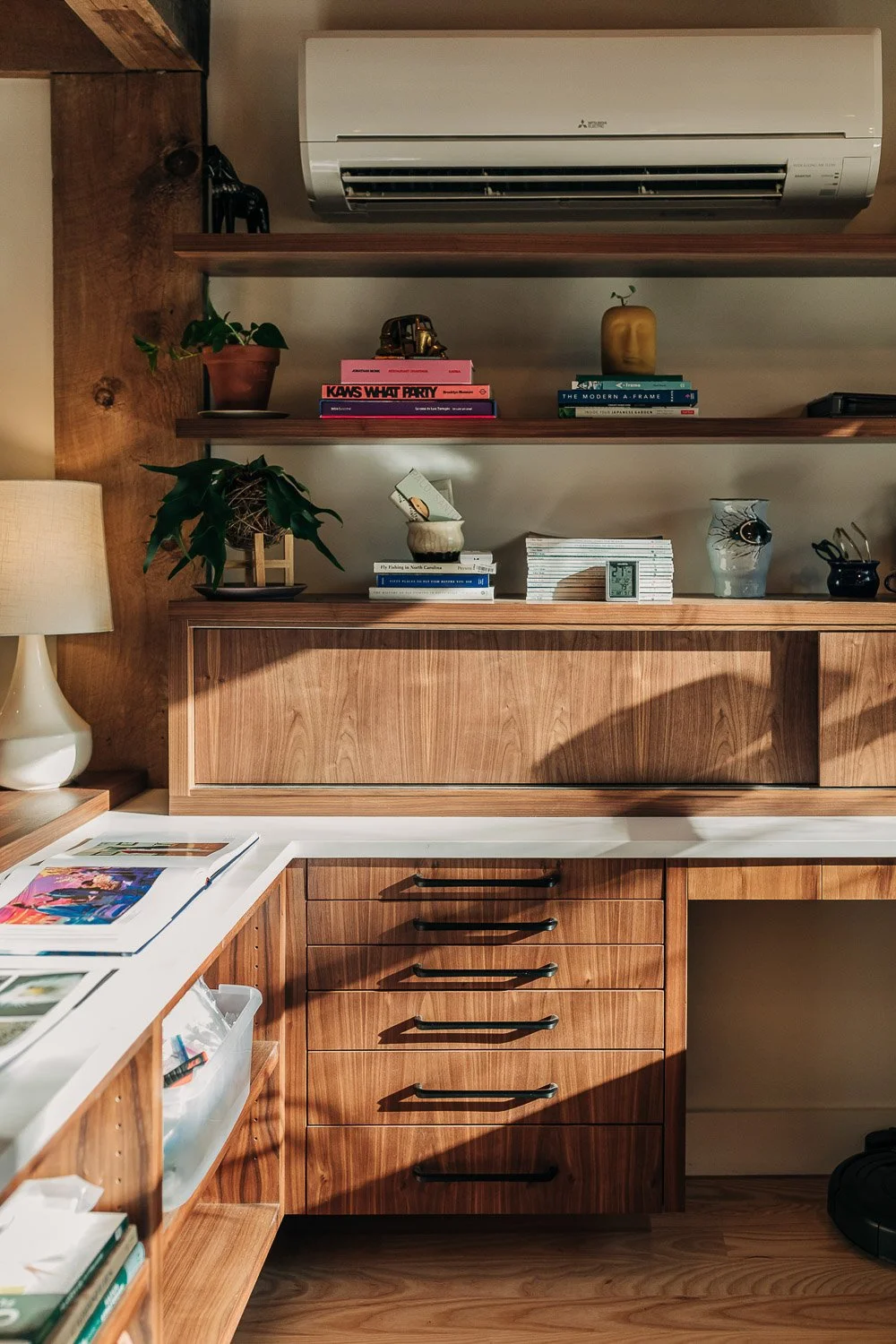 Built-in fly tying station desk with custom black walnut grain matched wood cabinetry and functional storage integrated into millwork system in Bat Cave NC