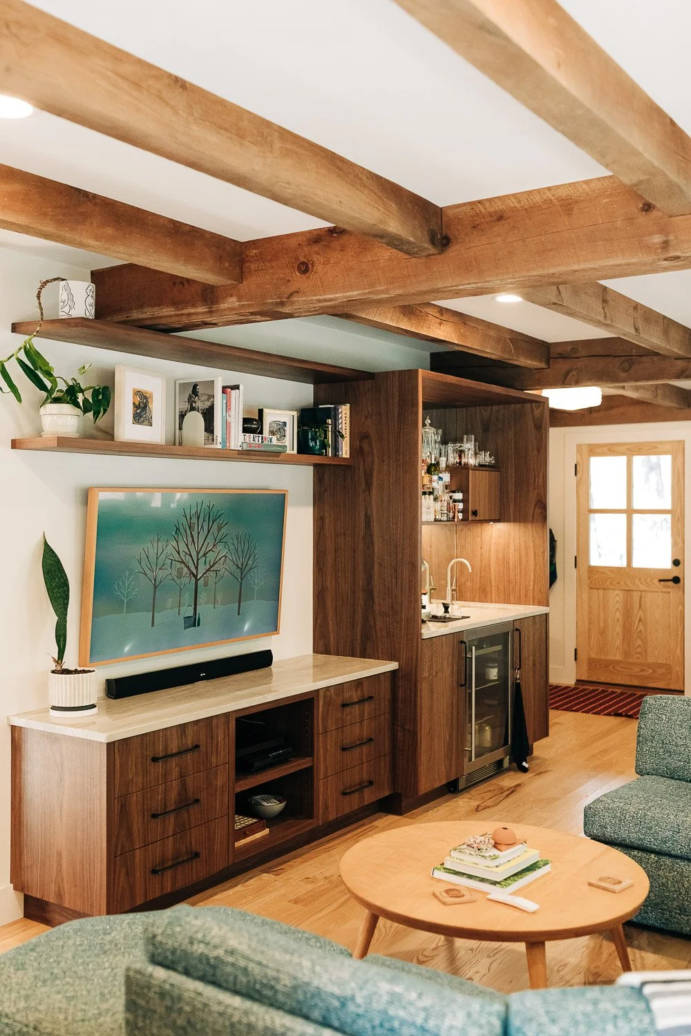 Custom black walnut built-in media and wet bar with integrated storage, beverage fridge, open shelving, and millwork cabinetry in mountain home near Lake Lure North Carolina