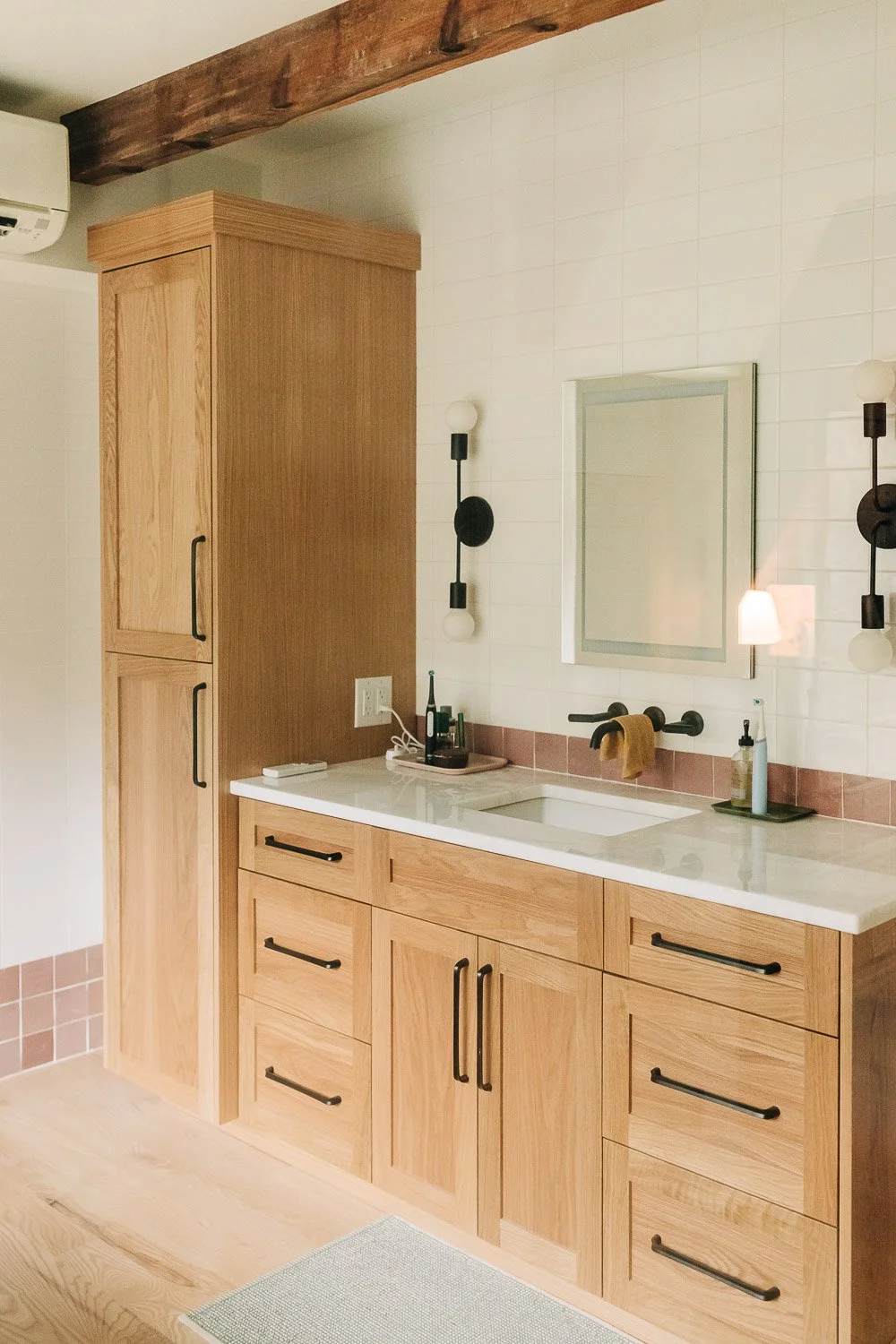 Custom white oak vanity with integrated storage, quartz countertop, and wall-mounted fixtures in Bat Cave North Carolina mountain home