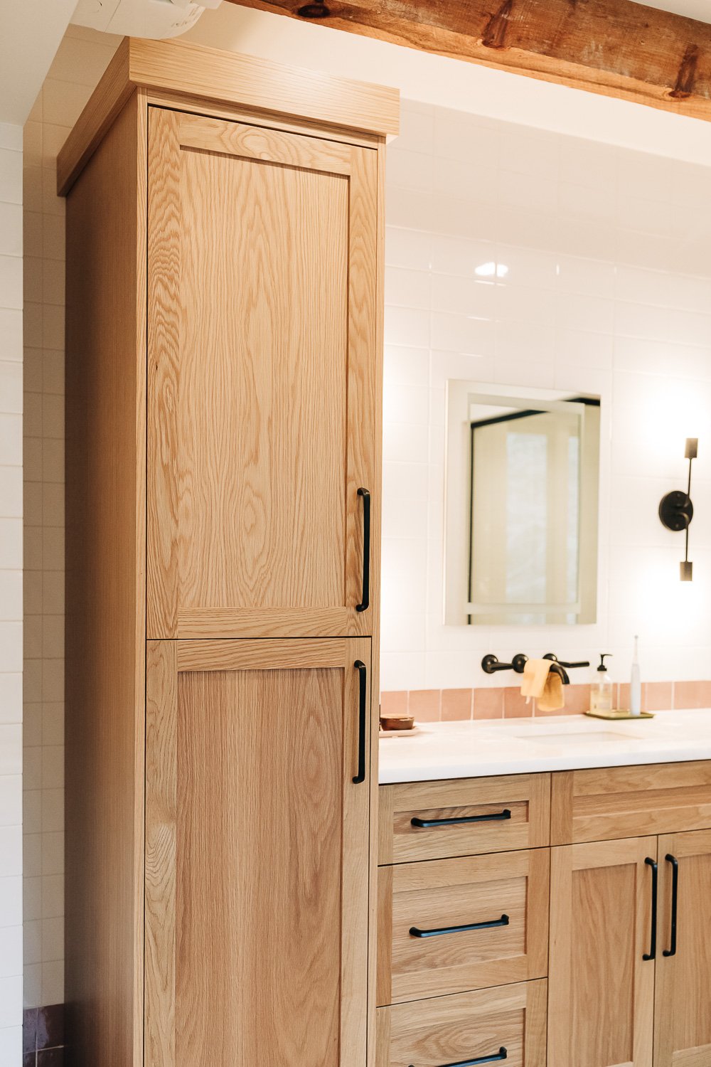 Custom white oak vanity with integrated storage, quartz countertop, and wall-mounted fixtures in Bat Cave North Carolina mountain home