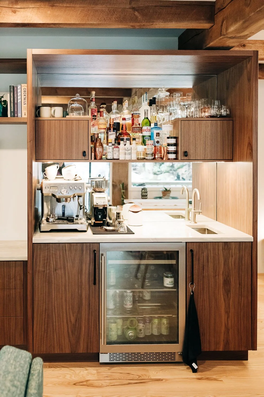 Custom black walnut coffee wet bar with integrated storage, beverage fridge, and millwork cabinetry in Bat Cave NC mountain home