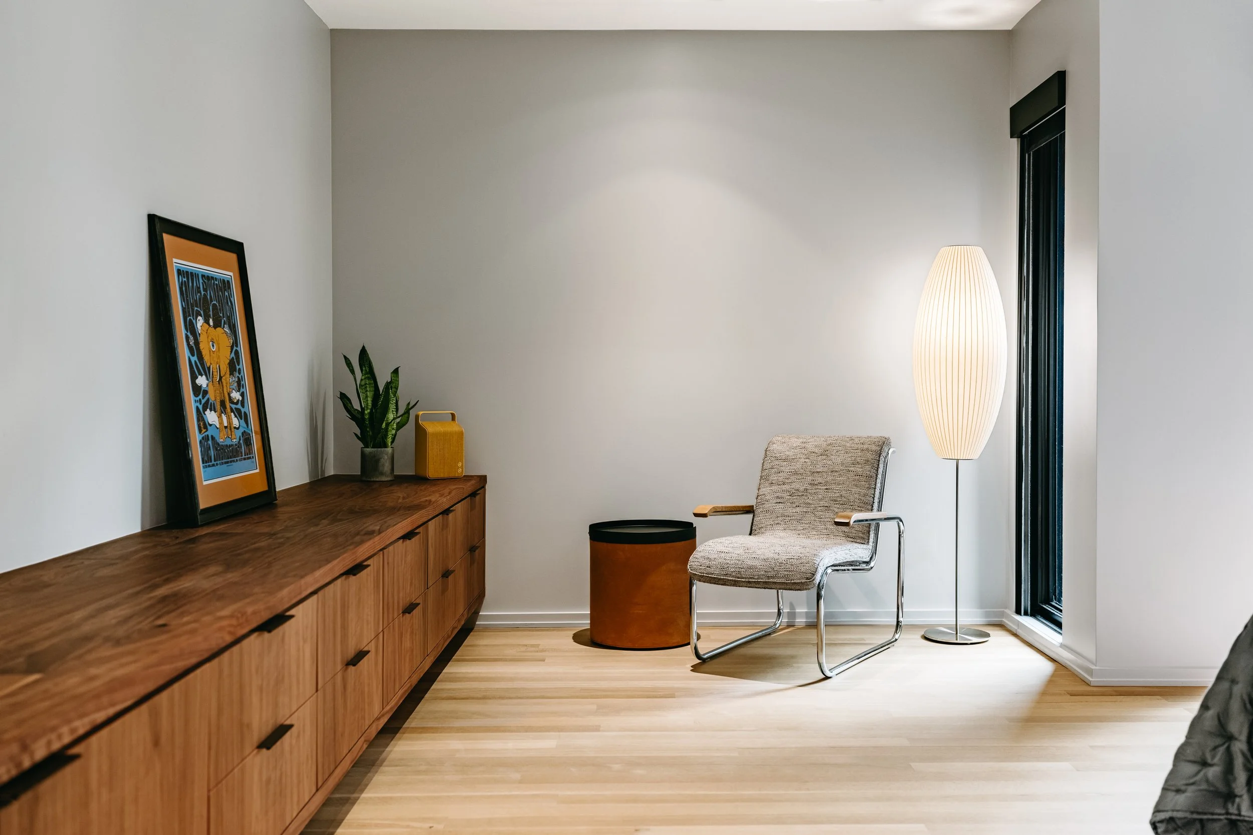 Custom woodwork by Sunnyside Millwork Custom 20-foot floating black walnut dresser with grain-matched veneer drawer fronts, precision scribed to fit irregular walls in Kernersville, North Carolina